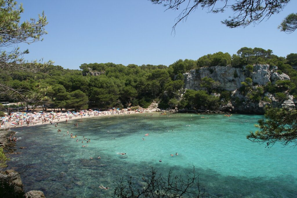 Cala Macarella, en Menorca, con agua turquesa y pinos